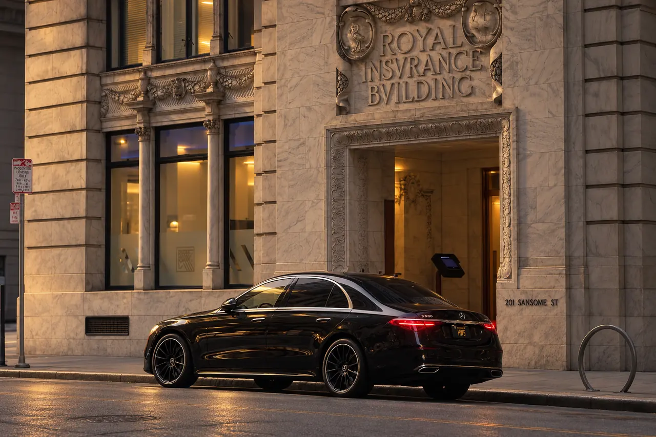 A black Mercedes S-Class outside a stone landmark building